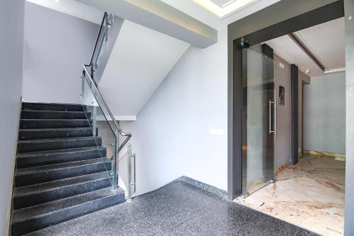 a staircase in a building with a glass door at FabHotel Prime The Water View Residency - Nr Bisarjan Ghat in Kolkata