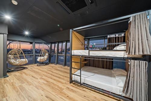 two bunk beds in a room with wood floors at The Pier Pods on the water- 50m from Townsville bus terminal and ferry terminal- Passport ID requried in Townsville