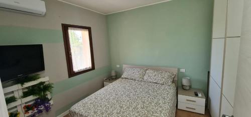a bedroom with a bed and a flat screen tv at Villa Chiara in San Teodoro