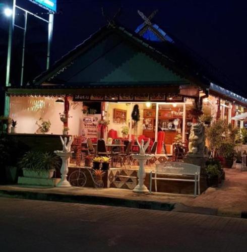 a restaurant with tables and chairs outside at night at Kasithorn Apartment's & Hotel in Phetchabun