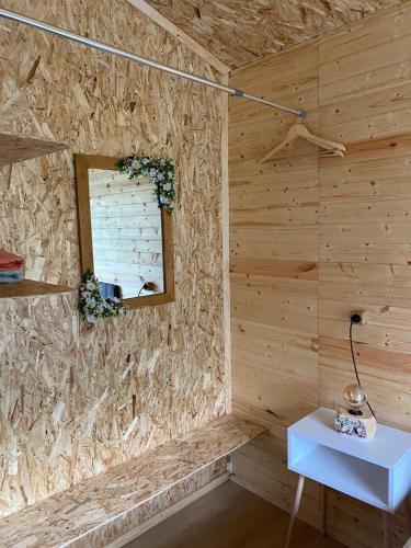a room with a wooden wall with a table and a window at COTTAGE cozy side in Mestia