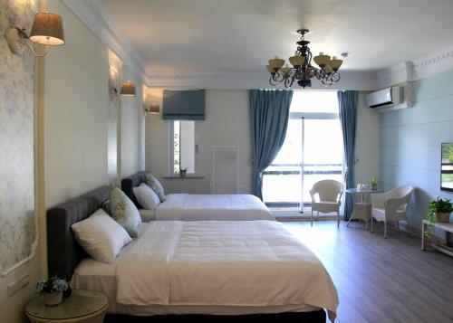 a hotel room with a large bed and a living room at HANA Homestay in Taitung City