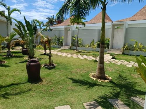 a yard with palm trees and a house at Pineale Villas, Resort and Spa in Panglao