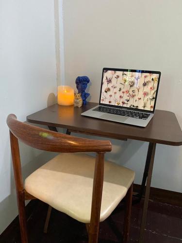 a laptop computer sitting on a table with a chair at Punkei home-Chiang Mai Center Near Sunday Market in Chiang Mai