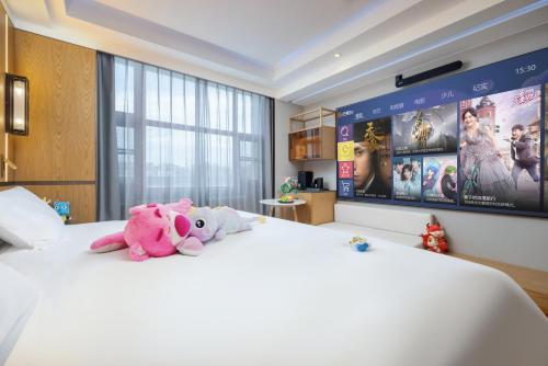 two stuffed animals sitting on top of a bed at Jingli Hotel - Beijing New National Exhibition Capital Airport in Houshayu