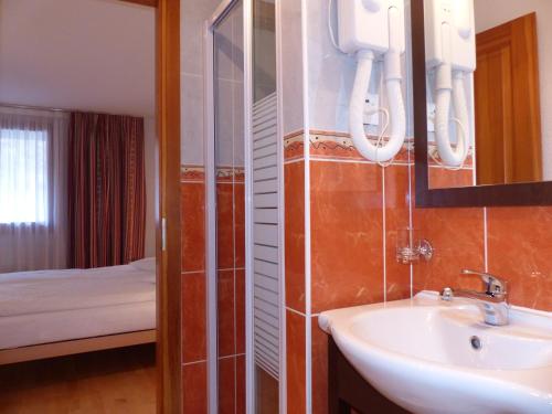 uma casa de banho com um lavatório, um espelho e uma cama em Residence Panorama em Villars-sur-Ollon