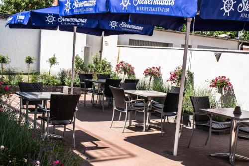 a row of tables and chairs with blue umbrellas at City Hotel in Bremerhaven