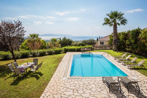 a swimming pool with chairs and a table and a house at Sun Villas in Sarlata