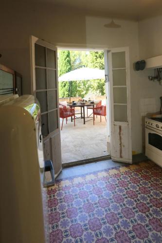 une cuisine avec une porte ouverte sur un patio dans l'établissement La suite du clos de la tour Cassis, à Cassis