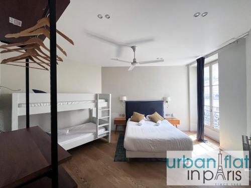 une chambre avec deux lits superposés et un ventilateur de plafond dans l'établissement Urban Flat 71 - Amazing Apartment in Le Marais, à Paris