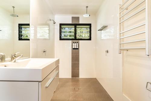 a white bathroom with a sink and a shower at BIG4 Saltwater Yamba Holiday Park in Yamba
