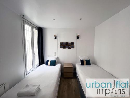 deux lits dans une chambre blanche avec une fenêtre dans l'établissement Urban Flat 14 - Charming 3 BDR Flat in Paris, à Paris
