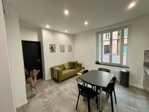 un salon avec une table et un canapé dans l'établissement L'Olivier - Calme, Chaleureux, proche transports, à Lyon