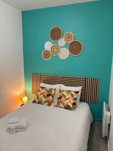 une chambre avec un grand lit avec un mur bleu dans l'établissement L'Olivier - Calme, Chaleureux, proche transports, à Lyon