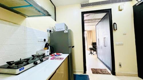 a kitchen with a stove and a refrigerator at BluO Studio - M Block Mkt Greater Kailash in New Delhi