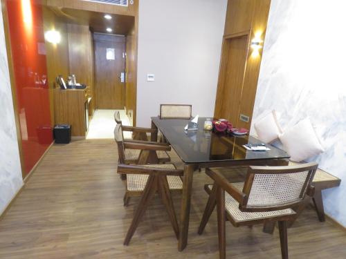a dining room with a black table and chairs at Lords Plaza Surat in Surat