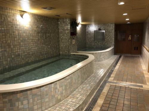 a large jacuzzi tub in a bathroom with a tv at Chuto Plaza Hotel in Taoyuan