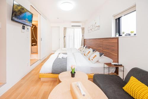 東京にあるNew Cozy APT Located on the Japanese Local shopping streetの大きなベッドとソファのある寝室