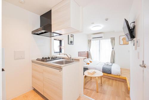 a small kitchen with a sink and a bedroom at New Cozy APT Located on the Japanese Local shopping street in Tokyo