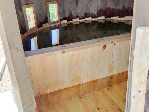 an empty room with wood floors and windows at 白馬森のわさび農園オートキャンプ場 in Hakuba