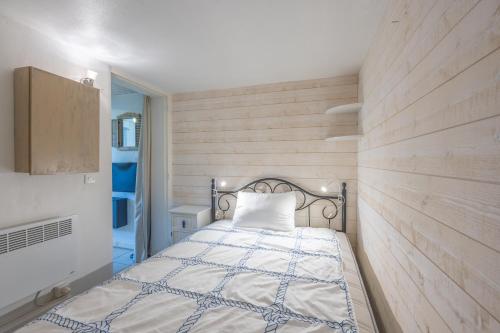 - une chambre avec un lit et un mur en bois dans l'établissement Le Petit Cocon Marin - Appt à 200m de la plage, à Courseulles-sur-Mer