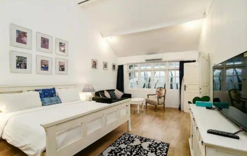 a bedroom with a large white bed and a desk at Villa 9C in Seminyak