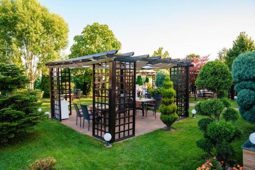 a gazebo with a table and chairs in a garden at Bacolux Craiovita, Craiova in Craiova
