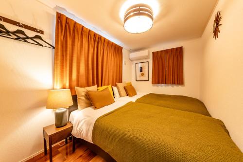 a bedroom with a bed and a lamp and a window at HOTEL Grand Star Tokyo in Tokyo