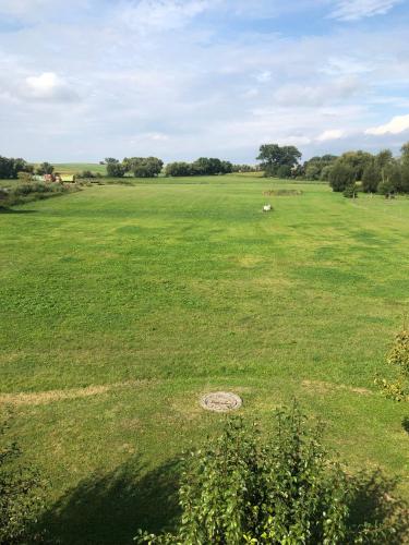 a large green field with a circle in the grass at Ferienwohnung Wiesenblick Dachgeschoß Sonnenberg Grambow in Sonnenberg