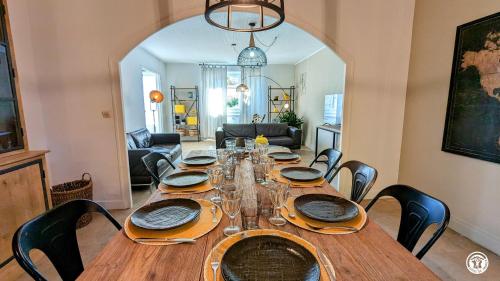 une table en bois avec des chaises et une salle à manger dans l'établissement La Maison Bleue, à Tillenay