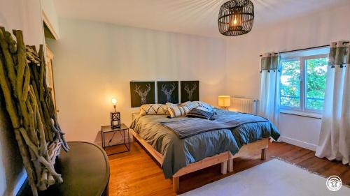 una camera da letto con un letto e una grande finestra di La Maison Bleue a Tillenay