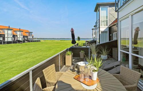 ヒュールスミンネにあるGorgeous Home In Juelsminde With Wifiのバルコニーにテーブルと椅子が置かれたパティオ