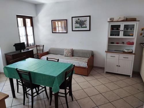 a living room with a table and a bed at Alloggio in valle maira in Macra