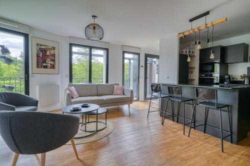 un salon avec un canapé et une cuisine dans l'établissement Chambre cosy - cadre verdoyant - proche Saclay, à Gif-sur-Yvette