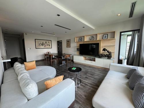 a living room with two white couches and a television at W8 CONDO, TOP Floor LUXE 3 Bedroom Penthouse, Hip central Bangkok area, 5 mins from Thonglo BTS station in Bangkok