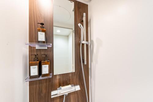 a bathroom with a mirror and bottles on a wall at HOTEL Grand Star Tokyo in Tokyo