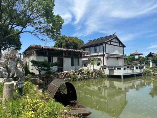 a house next to a river with a bridge at 陌上是舍uptownFARM in Chang-she-chen