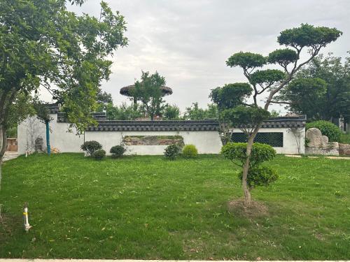 a house with a green yard with a tree at 陌上是舍uptownFARM in Chang-she-chen