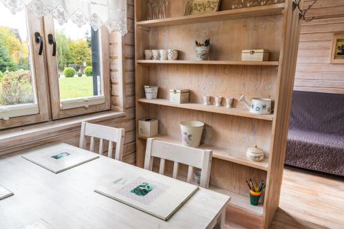 a room with a table and chairs and shelves at Biała Koszula in Tleń