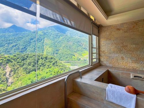 a bathroom with a window with a view of a mountain at Dongpo Ti Lun Hotel in Xinyi