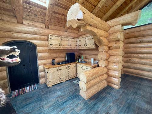 an interior of a log cabin with a kitchen in it at Cabana Ursilor in Vama