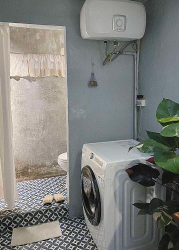 a washing machine in a bathroom with a toilet at Căn hộ số 9 - Di House Đà Lạt in Da Lat