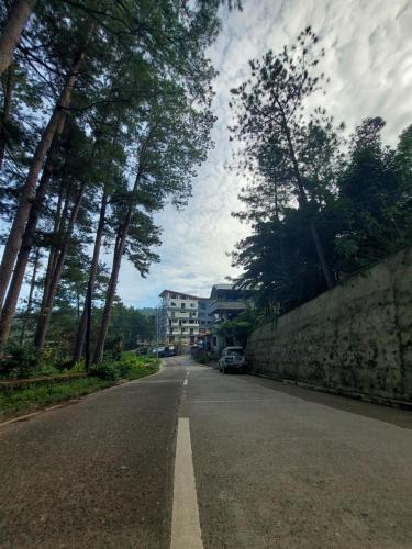 an empty street with trees on the side of the road at Quarrybay Hometel Sagada in Sagada