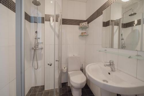 a white bathroom with a toilet and a sink at TwentySix in Malmö