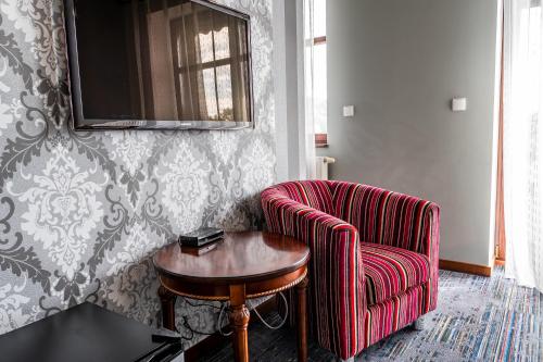 a living room with a chair and a table at Biała Koszula in Tleń