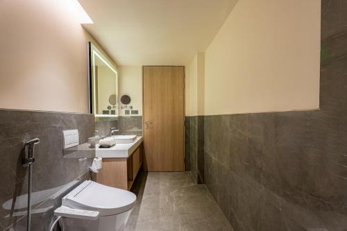 a bathroom with a toilet and a sink and a mirror at Park Inn by Radisson Vellore in Vellore