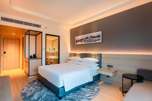 a bedroom with a white bed and a bathroom at Park Inn by Radisson Vellore in Vellore