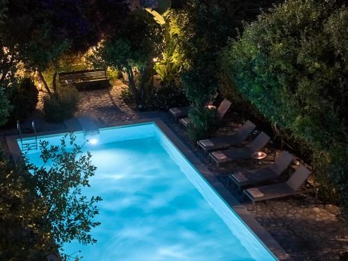 an overhead view of a swimming pool with lounge chairs and trees at Muazzo Historic Residence, in the Village Core, By ThinkVilla in Pigi