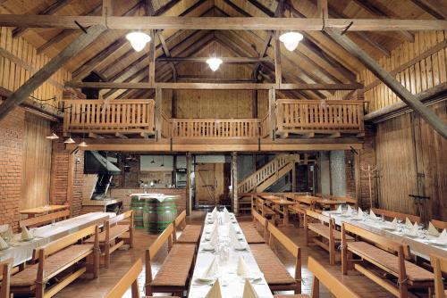 a dining room with tables and chairs and wooden ceilings at Penzion Pivovar Vraník in Trnava