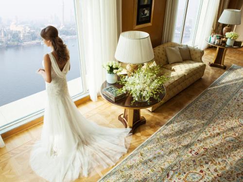 a bride in a wedding dress standing in a living room at Four Seasons Hotel Cairo at Nile Plaza in Cairo